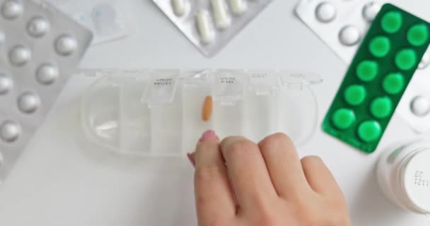 女人手把药丸放进开着的药丸柜或塑料药盒里 根据医生处方对日常使用的药片进行分类 — 图库视频影像