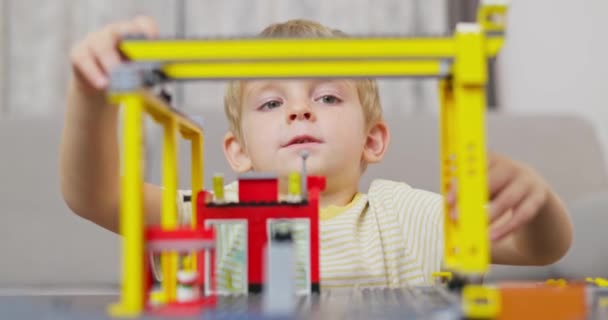 Chlapec Hraje Staví Barevnými Plastovými Cihlami Stolu Předčasné Učení Rozvoj — Stock video