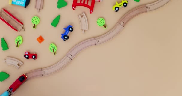带有汽车的玩具木制火车在米色背景的铁路上 带着儿童玩具 复制空间 玩具商店或开发游戏中心的广告 顶部视图 高质量的4K镜头 — 图库视频影像