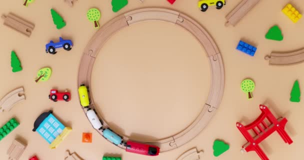 带有汽车的玩具木制火车在米色背景的圆圆的铁路上骑着儿童玩具 复制空间 玩具商店或开发游戏中心的广告 顶部视图 高质量的4K镜头 — 图库视频影像