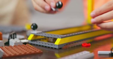 Masada renkli plastik tuğlalarla oynayan ve inşa eden çocuk. Erken öğrenme ve geliştirme. Yüksek kalite 4k görüntü