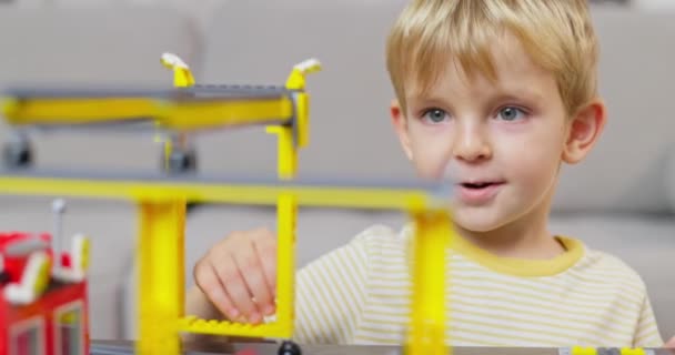 Gyerek Fiú Játszik Épít Színes Műanyag Téglákkal Asztalnál Korai Tanulás — Stock videók