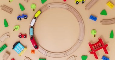Arabalı oyuncak ahşap tren bej arka planda çocuk oyuncaklarıyla demiryolunda gidiyor. Uzayı kopyala Oyuncakçı ya da oyun merkezi reklamı. Üst Manzara. Yüksek kalite 4k görüntü