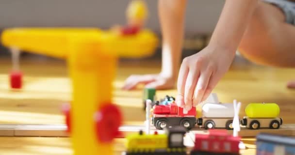소년은 아이들의 철도와 놀고있다 아이는 바닥에 장난감과 재생합니다 철도에 장난감 — 비디오