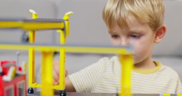 Kind Jongen Spelen Bouwen Met Kleurrijke Plastic Bakstenen Aan Tafel — Stockvideo