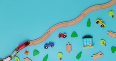 Arabaları olan oyuncak ahşap tren, mavi arka planda, çocuk oyuncaklarıyla demiryolunda. Uzayı kopyala Oyuncakçı ya da oyun merkezi reklamı. Üst Manzara. Yüksek kalite 4k görüntü