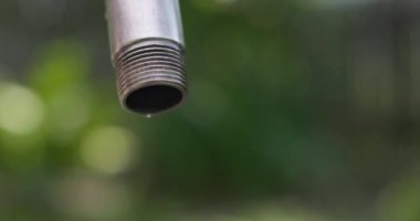 Sızdıran bir musluktan damlayan su bulanık bir arka planda. Su tasarrufu konsepti. Yüksek kalite 4k görüntü