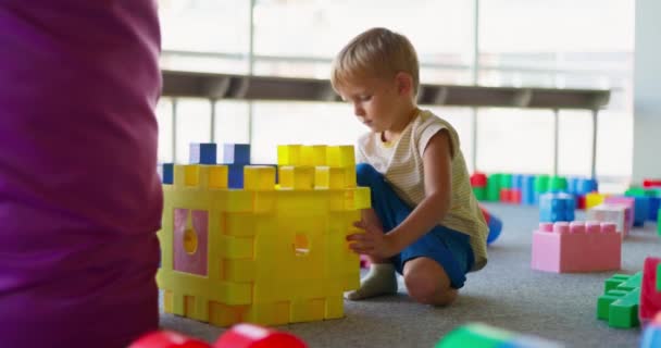 Ein Kind Spielt Einem Unterhaltungszentrum Oder Kindergarten Mit Spielzeugbausteinen Konzept — Stockvideo