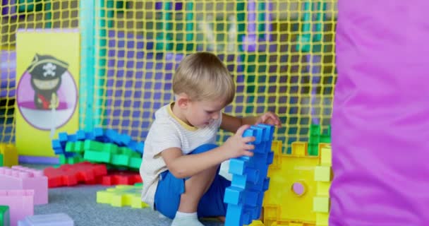 Ένα Παιδί Παίζει Δομικά Στοιχεία Παιχνιδιών Ένα Παιδικό Κέντρο Ψυχαγωγίας — Αρχείο Βίντεο