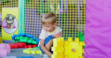 Bir çocuk, çocuk yuvasında ya da çocuk yuvasında oyuncak yapı taşlarıyla oynar. Erken gelişim, eğlence ve eğlence konsepti. Yüksek kalite 4k görüntü