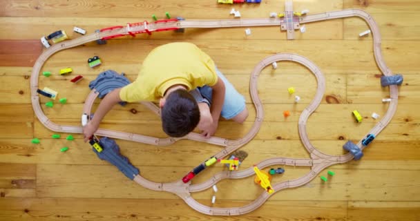 可爱的孩子在家里的地板上玩玩具木铁路 高质量的4K镜头 — 图库视频影像