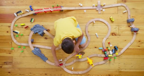 Χαριτωμένο Παιδί Παίζει Παιχνίδι Ξύλινο Σιδηρόδρομο Στο Πάτωμα Στο Σπίτι — Αρχείο Βίντεο