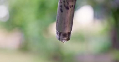 Sızdıran bir musluktan damlayan su bulanık bir arka planda. Su tasarrufu konsepti. Yüksek kalite 4k görüntü