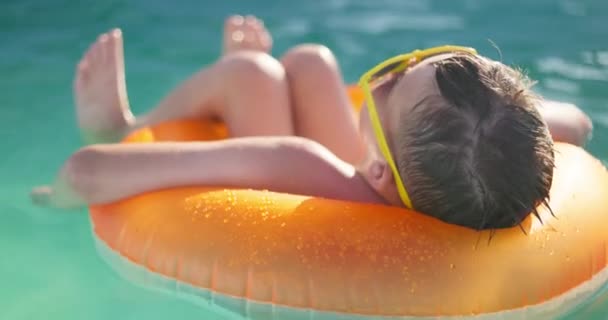 Chłopiec Żółtych Okularach Zrelaksował Się Pływając Basenie Nadmuchiwanym Pierścieniu Dzieciak — Wideo stockowe