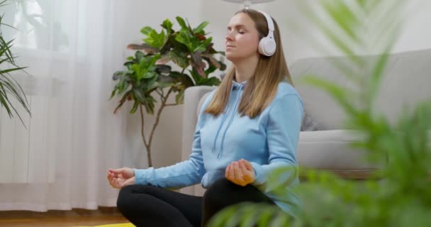 Eine Frau Setzt Kopfhörer Auf Ganz Den Meditationsprozess Einzutauchen Während — Stockvideo