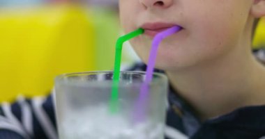 Küçük bir çocuğun fast food restoranında pipetle Mojito kokteyli içmesi. Yüksek kalite 4k görüntü