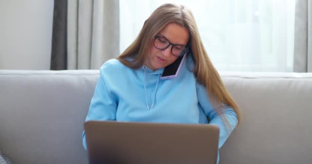 一位专心致志的女士在家里用笔记本电脑接了一个电话高质量的4K镜头 — 图库视频影像