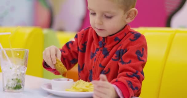 Anak Dengan Sweater Merah Menikmati Nugget Ayam Dengan Latar Belakang — Stok Video