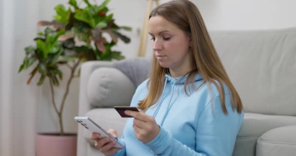 Skupiona Kobieta Niebieskiej Bluzie Używająca Smartfona Karty Kredytowej Zakupów Online — Wideo stockowe