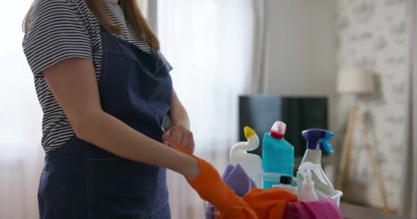 Pessoa Camisa Listrada Avental Colocando Luvas Limpeza Laranja Com Suprimentos — Vídeo de Stock