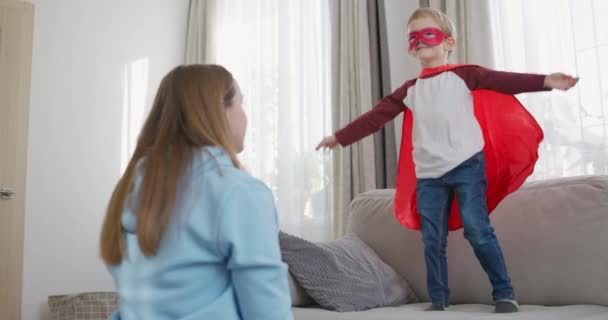 Młody Chłopiec Kostiumie Superbohatera Bawiący Się Matką Domu Przypadkowa Rodzinna — Wideo stockowe