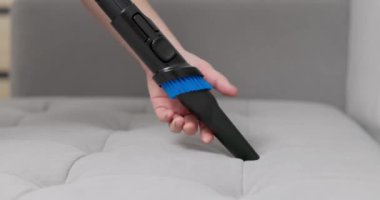 Etkili bir kanepe temizliği için elektrikli süpürgeye fırça takılı bir el resmi. Yüksek kalite 4k görüntü