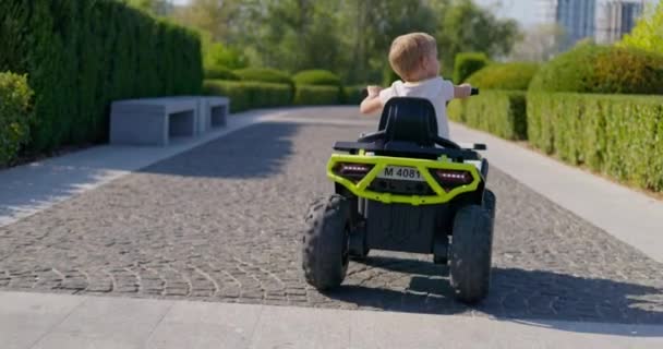 Widok Tyłu Małego Dziecka Korzystającego Przejażdżki Zabawkowym Samochodem Elektrycznym Słonecznej — Wideo stockowe
