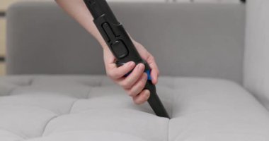 Etkili bir kanepe temizliği için elektrikli süpürgeye fırça takılı bir el resmi. Yüksek kalite 4k görüntü