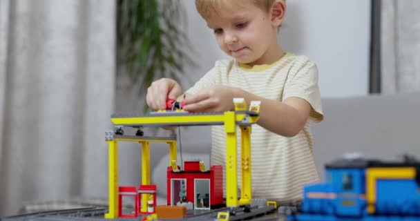 焦点を当てた子供が家の設定に設定されたカラフルなおもちゃの列車を組み立て 創造性を披露し 遊びを通して学びます 高品質の4K映像 — ストック動画