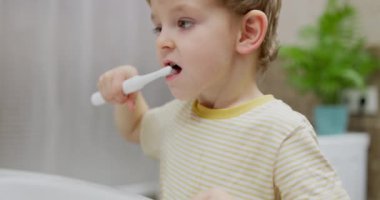 Banyoda diş fırçasıyla diş fırçalayan küçük bir çocuk. Günlük rutin ve diş temizliği konsepti. Sağlık sigortası, eğitim materyali, ebeveynlik blogu için tasarım. Yüksek kalite 4k görüntü