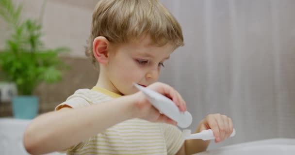 Junge Trägt Zahnpasta Auf Zahnbürste Badezimmer Auf Close Offenen Schuss — Stockvideo