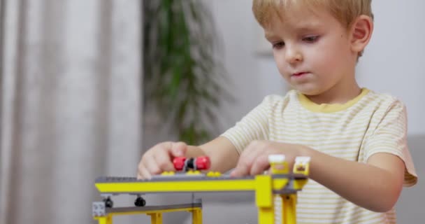 焦点を当てた子供が家の設定に設定されたカラフルなおもちゃの列車を組み立て 創造性を披露し 遊びを通して学びます 高品質の4K映像 — ストック動画