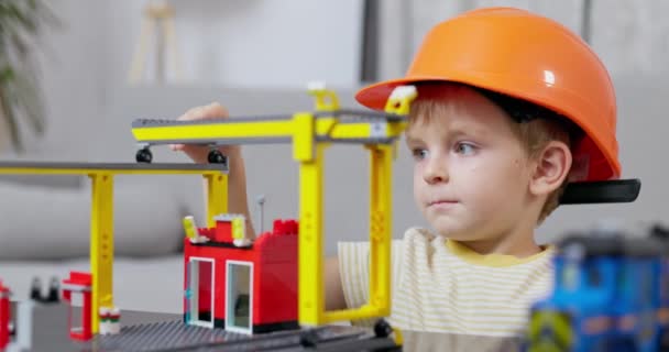 Mały Chłopiec Twardym Kapeluszu Skupił Się Budowie Placu Budowy Zabawek — Wideo stockowe