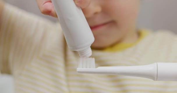 Kind Trägt Zahnpasta Auf Eine Zahnbürste Auf Zahnhygiene Aus Nächster — Stockvideo