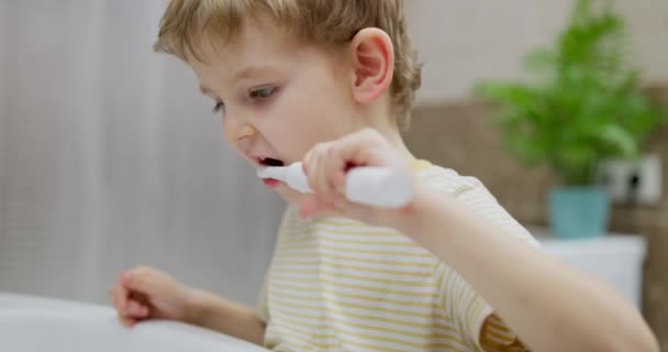 Маленький Мальчик Полосатой Рубашке Практикуется Чистить Зубы Современной Ванной Комнате — стоковое видео