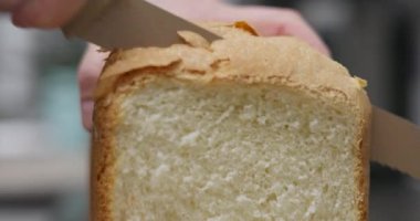 Tırtıklı bıçakla ev yapımı ekmek dilimlemek. Ev yemeği ve pişirme konsepti. Yemek tarifi blogu için tasarım, mutfak sitesi. Yüksek kalite 4k görüntü