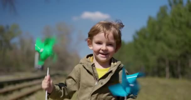 Joyeux Garçon Qui Court Avec Des Roues Bleues Vertes Dehors — Video