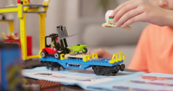 カラフルなおもちゃの建設セットを構築する子供の手 フィールドの浅い深さのクローズアップショット 子供時代と創造性のコンセプト 高品質の4K映像 — ストック動画