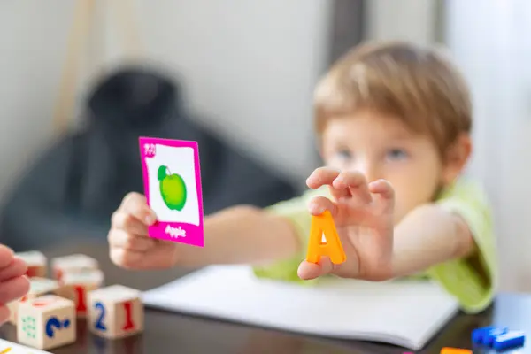 stock image Young child learning the alphabet using flashcards and colorful toys, engaging in educational playtime activities