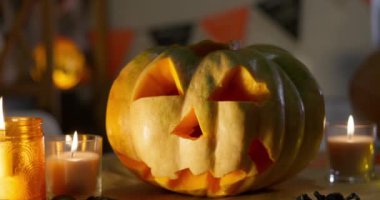 Mumlarla çevrili oyulmuş bir balkabağı balkabağı, ürkütücü bir Cadılar Bayramı atmosferi yaratıyor. Yüksek kalite 4k görüntü