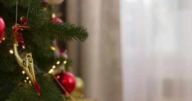Kırmızı ve altın süslemelerle Noel ağacını süsleyen çocuk. Ağaç dalında asılı duran ellerin yakın çekimi. Yüksek kalite 4k görüntü