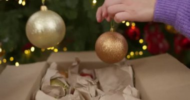 Bir anne ve oğlu Noel ağacını altın ve kırmızı aksesuarlarla süsleyerek Noel ruhunu artırıyor. Yüksek kalite 4k görüntü