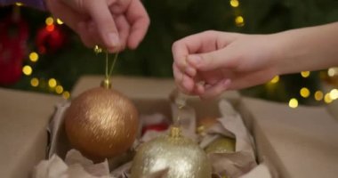 Bir anne ve oğlu Noel ağacını altın ve kırmızı aksesuarlarla süsleyerek Noel ruhunu artırıyor. Yüksek kalite 4k görüntü