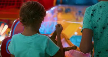 İki çocuk renkli bir korsan temalı atari oyunu ile etkileşime girerler, parlak neon ışıklarının altında bir gemi tekerleği kullanırlar. Yüksek kalite 4k görüntü