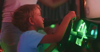 Parlak gösterge paneli ışıklarıyla oyun oynayan genç bir çocuk, saf heyecan ve eğlence dolu bir anda yakalandı. Yüksek kalite 4k görüntü