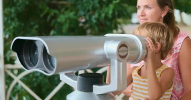 Bir anne ve kız dışarıda bir günün tadını çıkarırlar, dürbünle çevrelerini gözlemlerler. Sahne, doğal ortamda bir bağ kurma ve keşif anı yakalar..