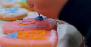 Kurabiyeleri renkli kremalarla süslerken çekilmiş yakın çekim videosu. Karmaşık tasarımlara ve canlı renklere odaklan. Pişirme dersleri ya da festival içeriği için ideal.