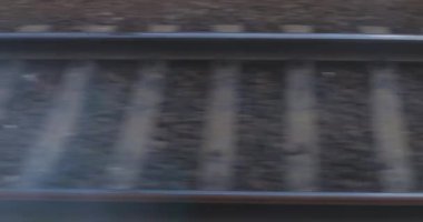 Hareket bulanıklığıyla yakalanan tren raylarının dinamik görüntüsü, hareket eden bir tren penceresinden görüldüğü gibi, hız ve seyahat dinamiklerini gösteriyor..