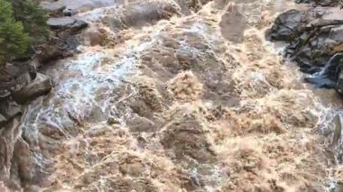 Kayalık arazide çağlayan güçlü bir şelalenin yüksek çözünürlüklü videosu. Çalkantılı su dinamik bir sahne yaratır, ham enerjiyi ve akan suyun güzelliğini gözler önüne serer..