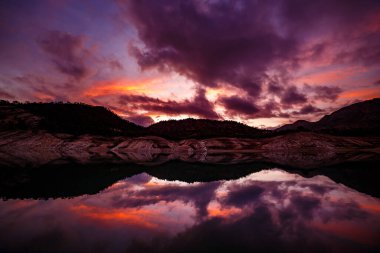Hills reflected in the Villajoyosa reservoir during sunset